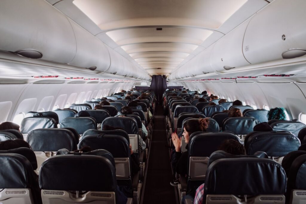 A view of passengers seated inside a commercial airplane cabin during flight.